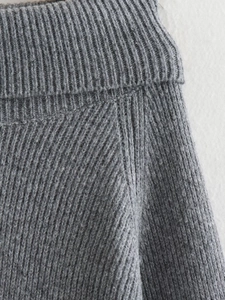 Close-up of the coarse knit texture and stitching on a slim-fit grey winter sweater