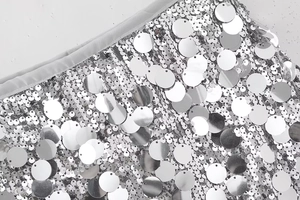 Détail de grandes paillettes argentées sur tissu mesh avec coutures de qualité