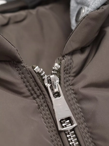 Close-up of durable silver metal zipper and textured fabric on winter puffer jacket