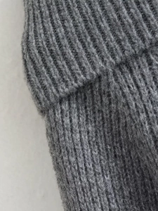 Close-up of grey ribbed knit texture with detailed ribbed stitching on winter sweater