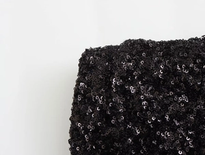 Gros plan détaillé montrant les paillettes noires scintillantes de la robe mini Y2K