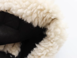 Détail de la doublure en peau de mouton synthétique crème et tissu matelassé noir