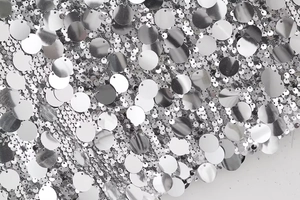 Détail macro de paillettes argentées scintillantes sur mesh blanc pour jupe Y2K