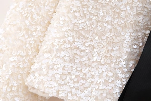 Macro detail of shimmering white sequins on Y2K slim-fit top with texture and shine