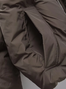 Detailed close-up of side pocket and fabric texture on warm winter puffer jacket