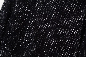 Vue macro de paillettes noires scintillantes sur le tissu du haut Y2K à manches longues