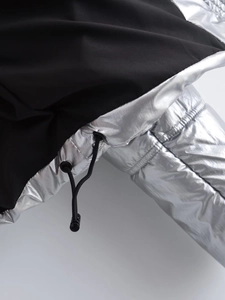 Détail de la veste Y2K montrant le tissu noir mat et les panneaux argentés métallisés