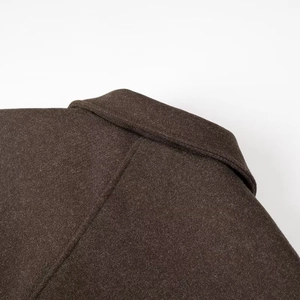 Detail of the brown wool coat collar showing premium texture and neat stitching