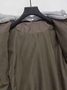 Detail of the inner lining and detachable grey hood with silver metal snap buttons