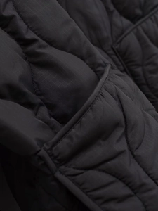 Vista macro del tessuto ripstop nero con trapuntatura a onde sul cappotto invernale