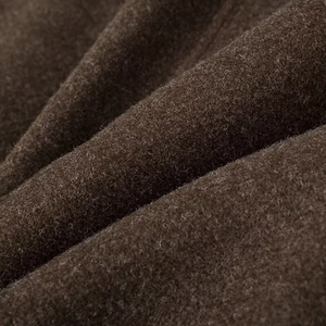 Macro shot of dark brown wool-like fabric texture with soft fiber detail and drape
