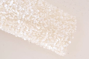 Macro shot of shimmering white sequins and delicate stitching on the Y2K slim blouse