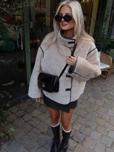 Chic beige faux fur jacket with contrast brown leather trim and stand-up collar