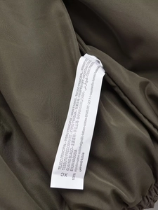 Close-up of the Y2K winter jacket fabric and 100% cotton material care label