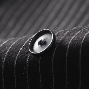 Macro shot of black buttons on pinstripe suit jacket showing fabric texture and detail