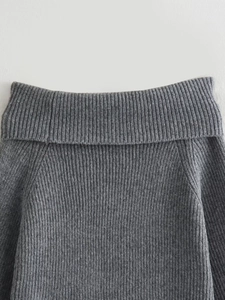 Close-up of grey ribbed knit sweater texture showing vertical stripes and fine craftsmanship