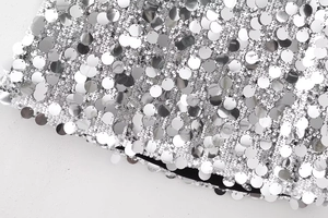 Détail de mini-jupe à paillettes argentées avec texture métallique et doublure noire