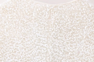Macro shot of high-density white sequins on a chic Y2K slimming top for women