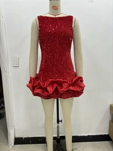 Détail de la mini-robe rouge sans manches à paillettes avec un ourlet en satin