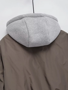 Detail view of winter puffer jacket with detachable grey knit hood and brown fabric