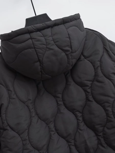 Dettaglio della trapuntatura a onde e cappuccio di questa giacca nera invernale