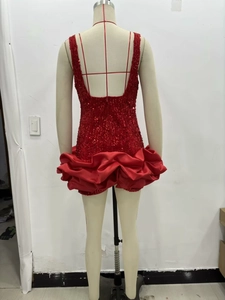 Détail de mini-robe rouge à paillettes avec dos nu et ourlet à volants en satin