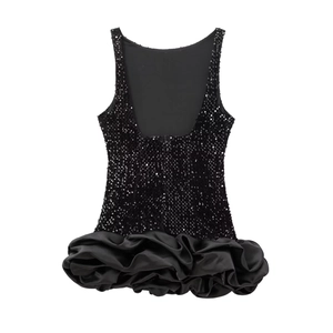 Détail d'une mini-robe à paillettes sans manches avec un ourlet en satin à volants