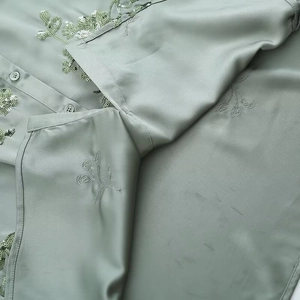 Close-up of light green satin shirt featuring intricate floral sequin embroidery details