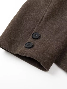 Deep brown wool short coat sleeve with two black decorative buttons and refined texture