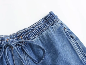 Detalle de los pantalones vaqueros Y2K azules con cintura elástica y cordón ajustable