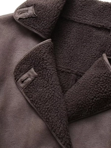 Nahaufnahme einer braunen Wildlederjacke mit dickem Lammfellfutter und verstärktem Knopfloch