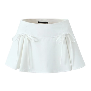 Detailed view of white high-waisted mini skirt with decorative bows and subtle pleats