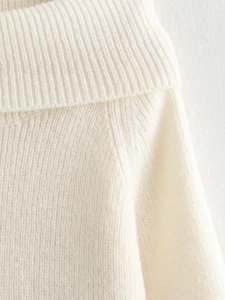 Close-up of the ribbed turtleneck and soft knit texture on this cream sweater