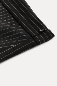 Close-up of pinstripe suit fabric featuring high-quality texture and hidden side zipper
