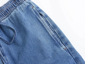 Detalle de los pantalones cortos vaqueros azules con cintura elástica y cordón