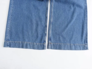 Detalle de los bajos de vaqueros azul claro que muestra las costuras y textura del denim