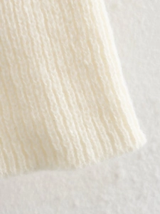 Macro shot of off-white ribbed knit texture with soft wool fibers on sweater edge
