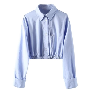 Close-up of baby blue cropped shirt featuring elastic hem and decorative chest pocket