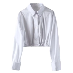 Detail of white cropped shirt featuring lapel collar and elasticated hemline design