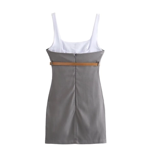 Détail de la robe contrastée avec haut blanc, jupe grise et ceinture marron élégante