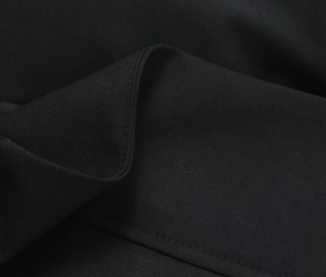 Close-up of black twill fabric with precise single-needle stitching and matte texture