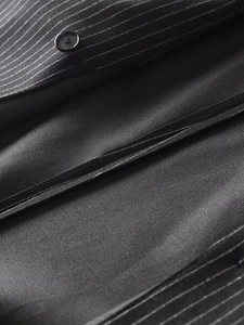 Close-up of Y2K pinstripe blazer fabric with fine texture and single breasted button