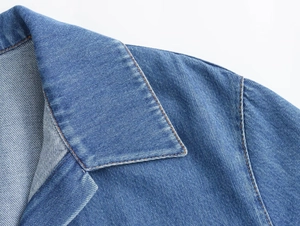 Detalle de las costuras en contraste y el tejido denim en el cuello de la camisa azul