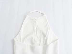 Detailed view of the white halter-neck design and open back on this slim-fit spring top