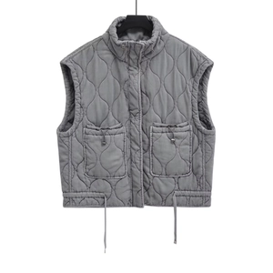 Dettaglio del gilet trapuntato grigio con grandi tasche a coulisse e collo alto moderno