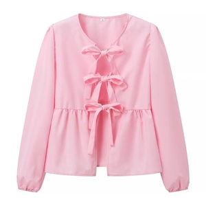 Close-up of pink long sleeve top showing front bow tie closures and ruffled hem detail