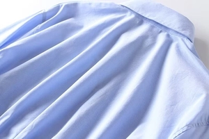 Close-up of the light blue shirt collar and back seam with high-quality stitching details