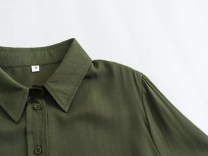 Close-up of asymmetrical dark green shirt collar with buttons and size S tag