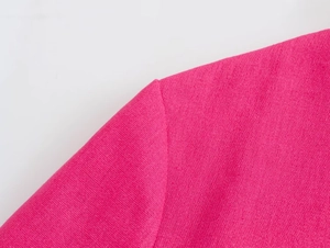 Macro detail of high-quality stitching on hot pink blazer shoulder with woven texture