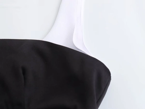 Détail du tissu sergé noir et de la bretelle blanche sur une robe dos nu